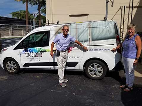 Owners posing for a photo with the company vehicle