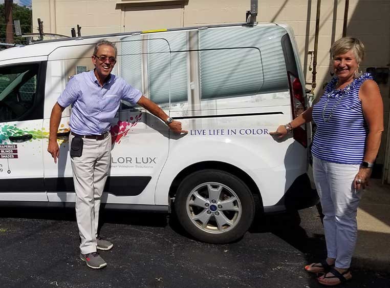 Owners posing for a photo with the company vehicle